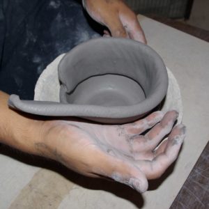 Adding the fist clay coil to the bowl