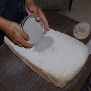 Adding water in preparation to grind the clay more