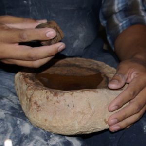 Grinding the brown paint stone to achieve proper concentration of pigment