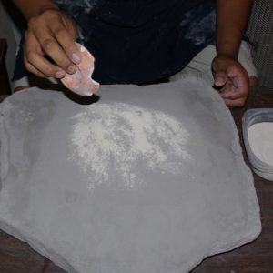 Adding more ground pottery shards to the clay powder