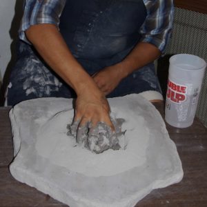 Hand mixing water and clay