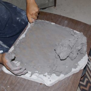 Roll the clay into a ball and scrape more clay off the mixing stone