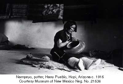 Nampeyo of Hano holding a pot in her lap as she paints it in 1915