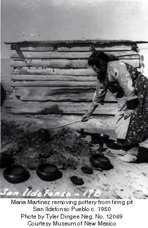 Maria using a stick to separate the pottery after firing