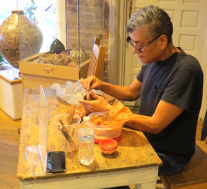 Hubert Candelario smooths the inner surface of a pot as he makes it