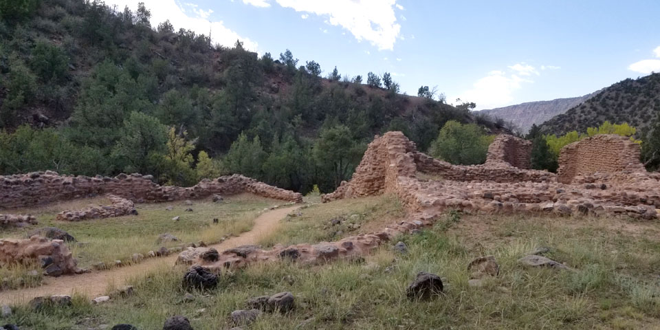 Looking northeast across the ruined walls of Giusewa toward the forest slopes and canyons of the Jemez Mountains