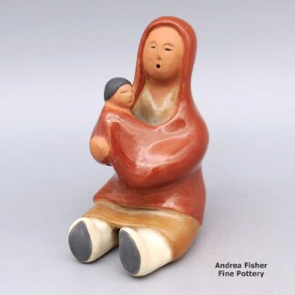 Polychrome grandmother storyteller figure holding one child in her arms