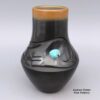 Dora Tse Pe, lksi2l332: Black jar with a carved avanyu design