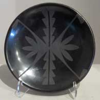 A black-on-black plate with a mirror-image geometric design